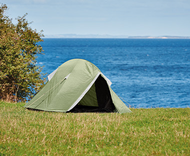 Mali zeleni šator na livadi pored mora