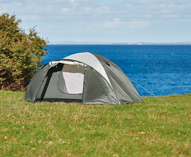 Praktični šator u tamno i svijetlo sivoj boji na livadi pored mora