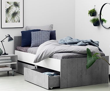 Krevet sivo bijele boje sa ladicama za pohranjivanje stvari