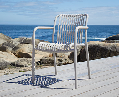 Bijela baštenska stolica na daščanoj terasi na suncu