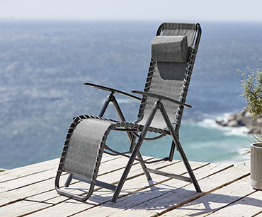 Baštenska sklopiva stolica za relaksaciju u crnoj boji na drvenom moru pored mora