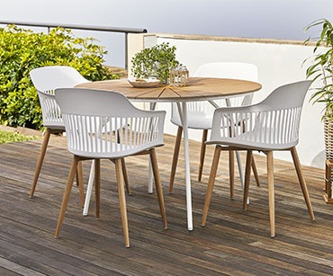 Lijepi okrugli baštenski stol sa bijelim nogama i bijele baštenske stolice na balkonu