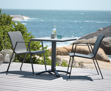 Bistro stol i dvije baštenske stolice na terasi s pogledom na more
