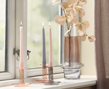 Prozorska daska sa staklenom vazom i svijećama