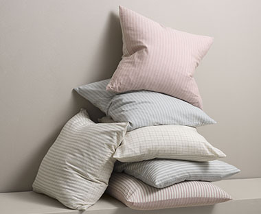 Ukrasni jastuci sa jastučnicama na crtice u raznim bojama 