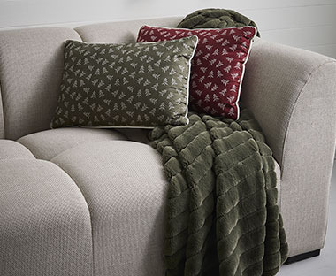 Bordo i maslinasto zeleni ukrasni jastuk i maslinasto zelena deka na kauču
