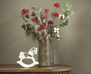 Mali ukrasni drveni konjići vaza sa buketom cvijeća