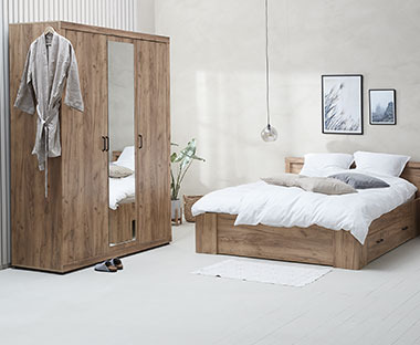 Drveni ormar sa ogledalom i bračni krevet u spavaćoj sobi