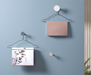 Dvije žičane vješalice okačene na zid i na njima časopisi