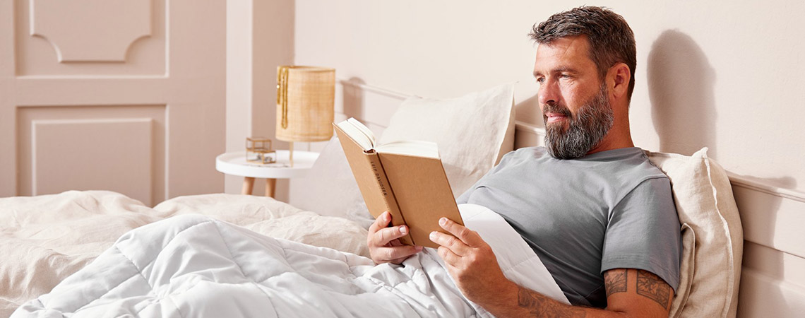 Muškarac čita u krevetu