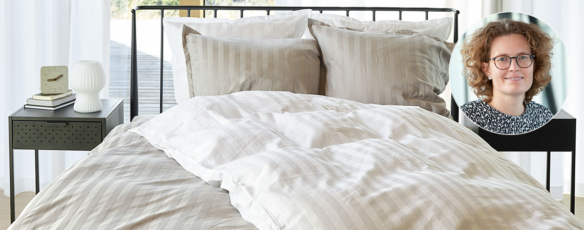 Spavaća soba sa krevetom, jorganima i jastucima, prekrivena prugastom posteljinom i Berit Christiansen
