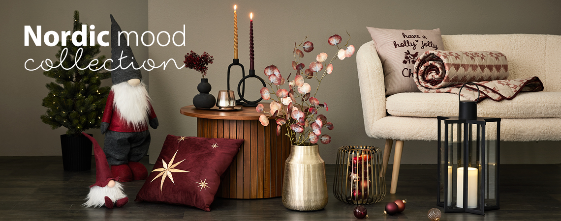 Novogodišnji vilenjaci, jastuci, zlatna vaza sa umjetnim cvijećem, zlatni svijećnjak i crni fenjer