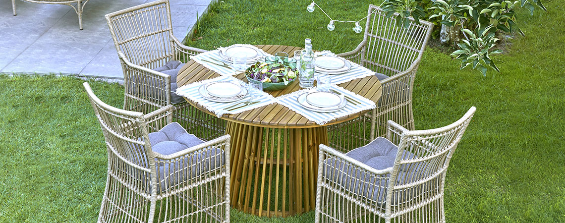Okrugli baštenski stol i četiri baštenske stolice u bašti