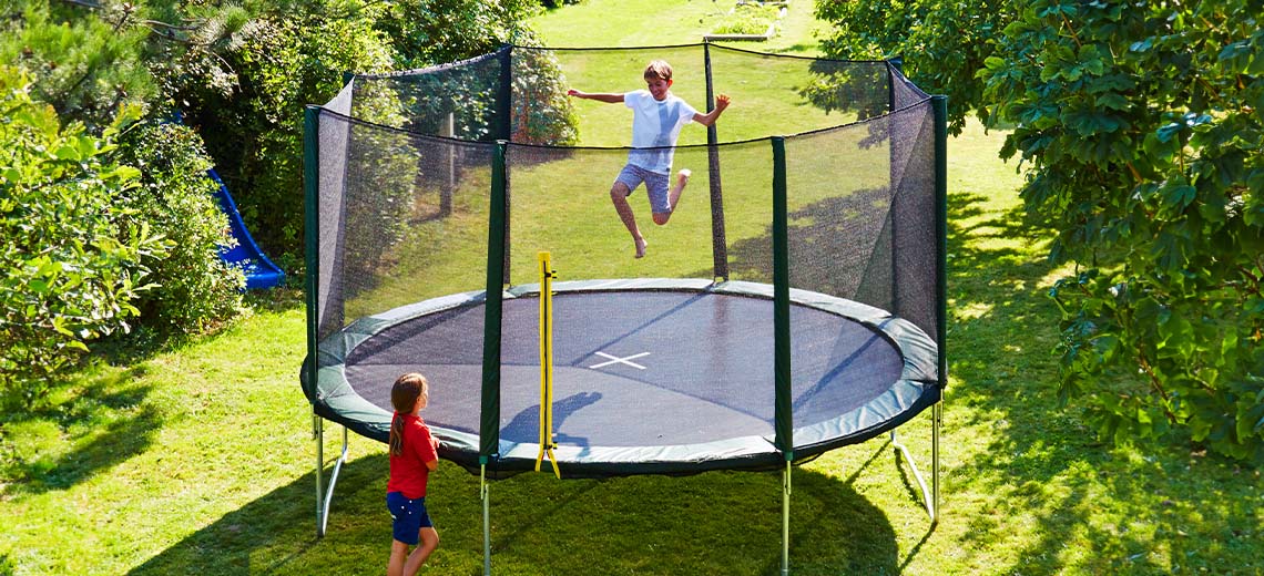 Djeca se igraju na velikoj trambolini u bašti