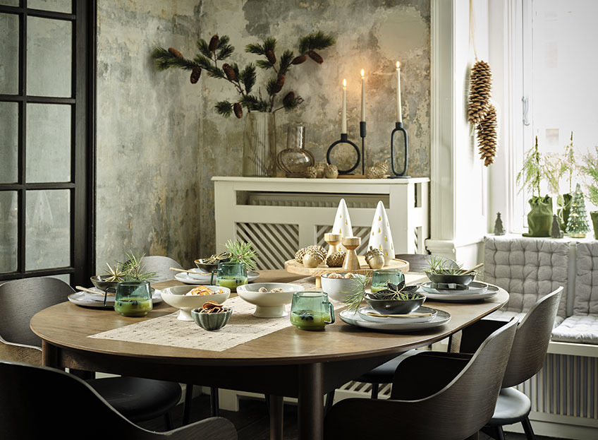 Postavljen novogodišnji stol sa zlatnim novogodišnjim nadstolnjakom, tanjirima, zdjelama i prazničnim dekoracijama