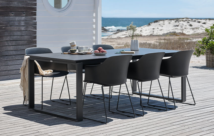 Veliki baštenski stol i stolice na terasi pored plaže