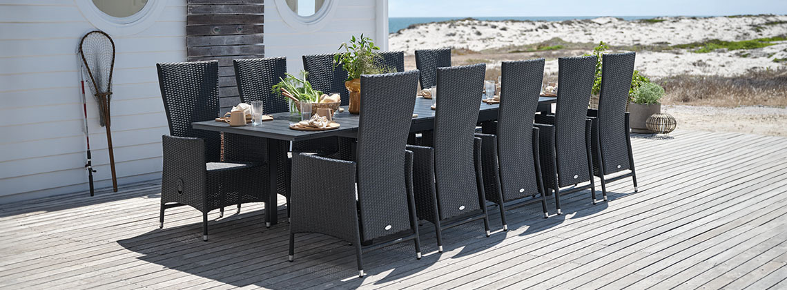 Veliki baštenski stol i stolice za 10 ili 12 osoba na terasi pored plaže