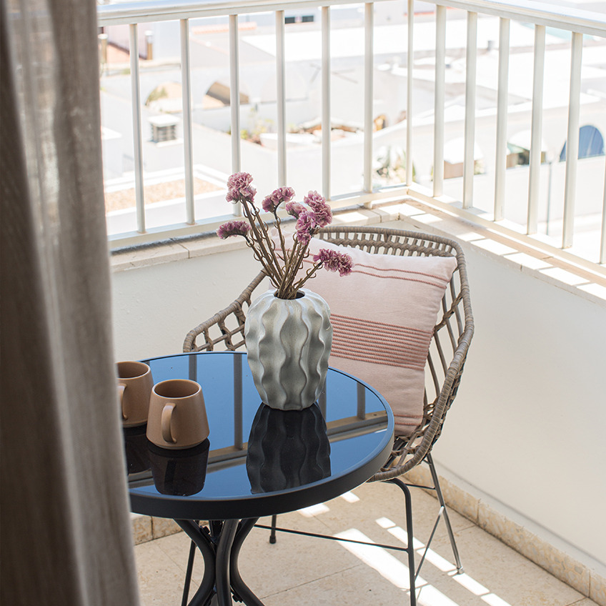 Balkon sa stolicom, stolom i dekoracijama.