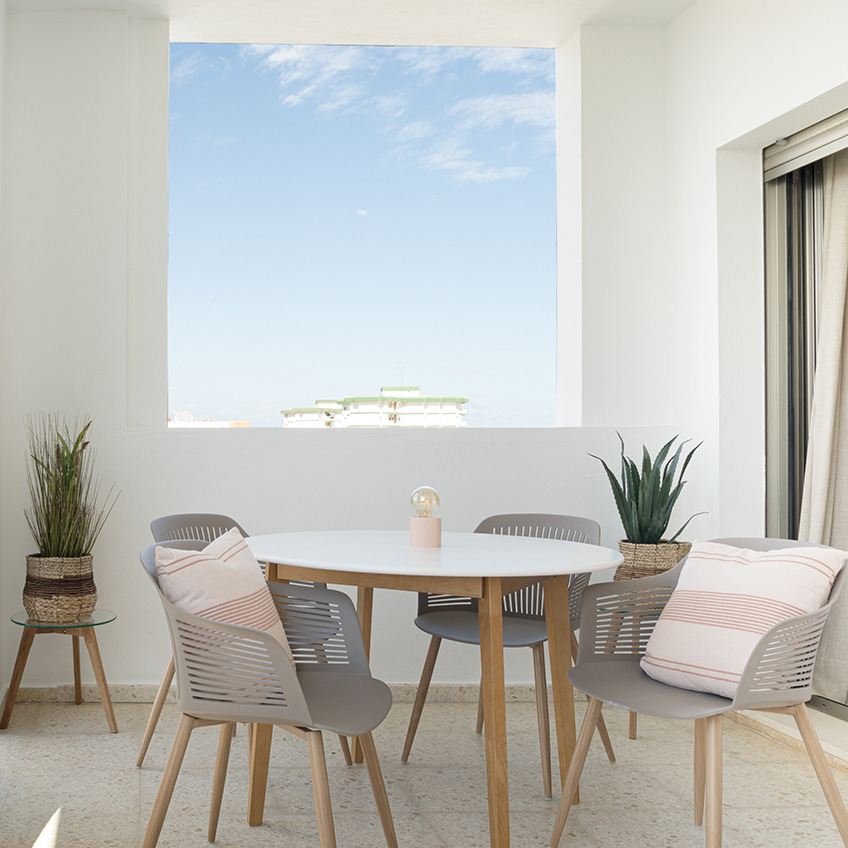 Balkon opremljen sa stolom, stolicama i dekoracijama.