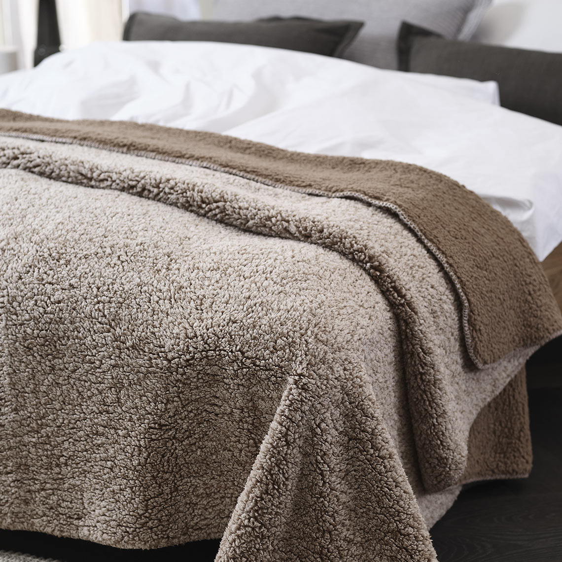 STORFRYTLE fleece throw Brown fleece throw on a bed in a bedroom
