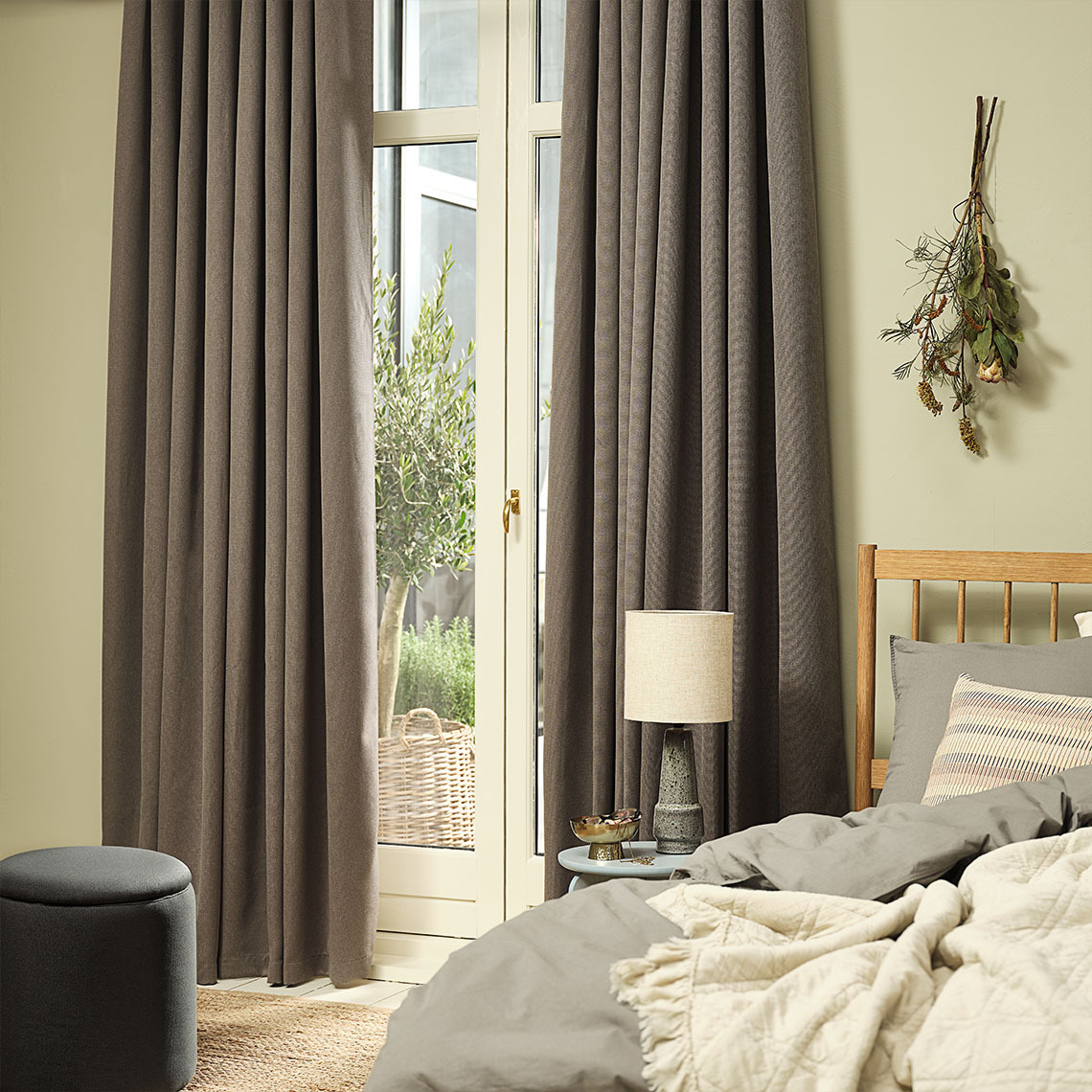 KVINGLA dimming curtain in warm grey Warm grey dimming curtains hung by a large window in a bedroom