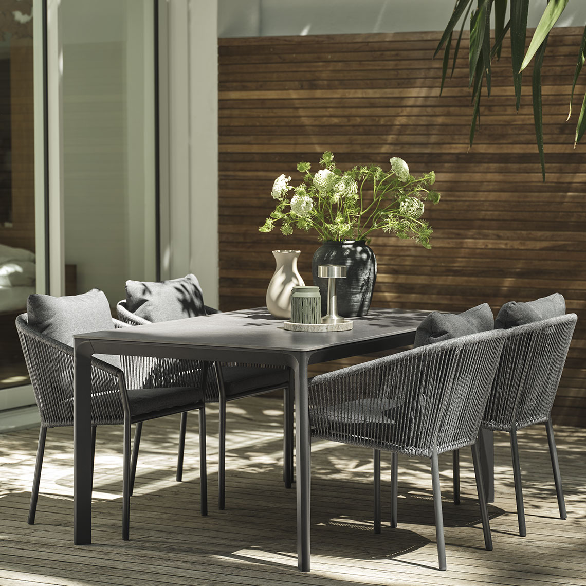 Postavljen baštenski stol i baštenske stolice na terasi u vrijeme sumraka