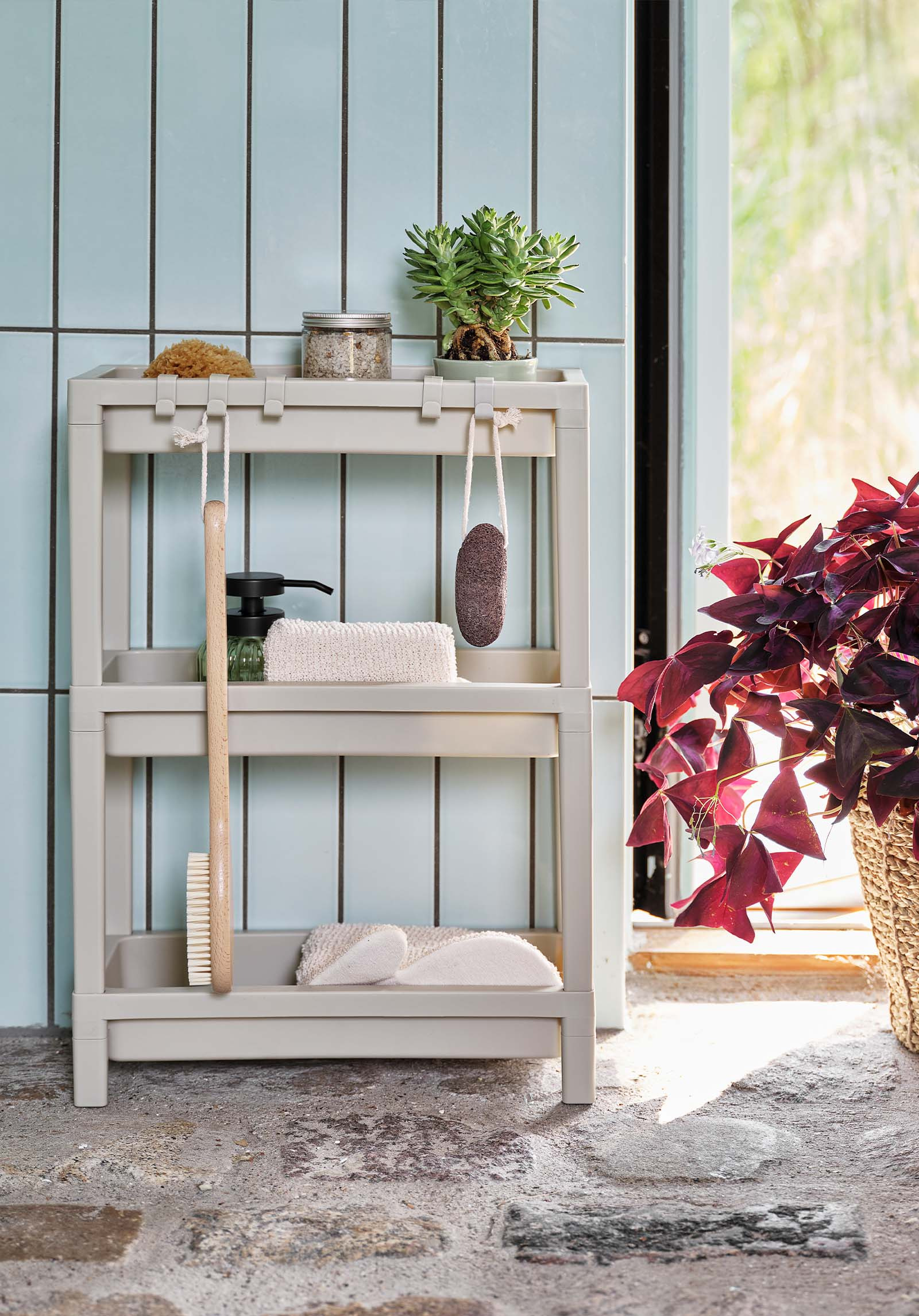 Plastic bathroom shelving unit in beige with toiletries 
