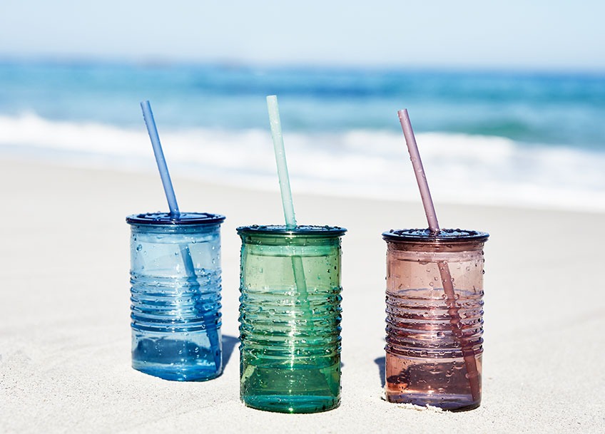 ALF plastične čaše sa slamkom dostupne u plavoj, zelenoj i crvenoj boji Tri čaše sa slamkom u raznim bojama u pijesku na plažu