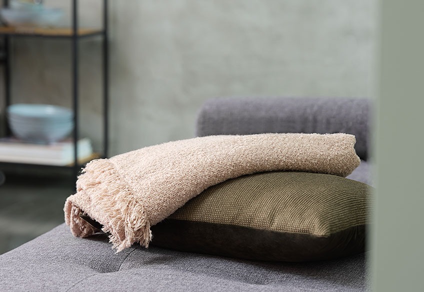 Mekana deka i ukrasni jastuk na sofi