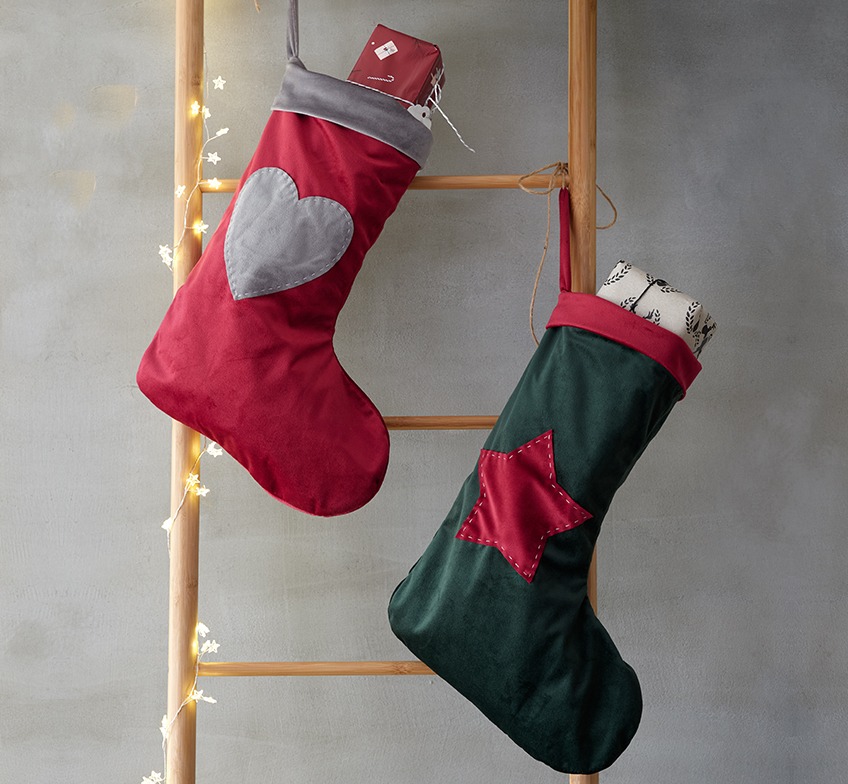 Novogodišnje čarape u crvenoj i zelenoj boji na dekorativnim ljestvama