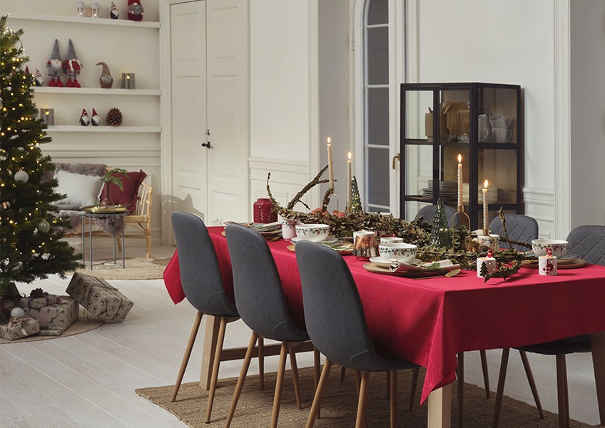 Trpezarijski stol ukrašen za doček Nove godine i novogodišnja jelka sa poklonima