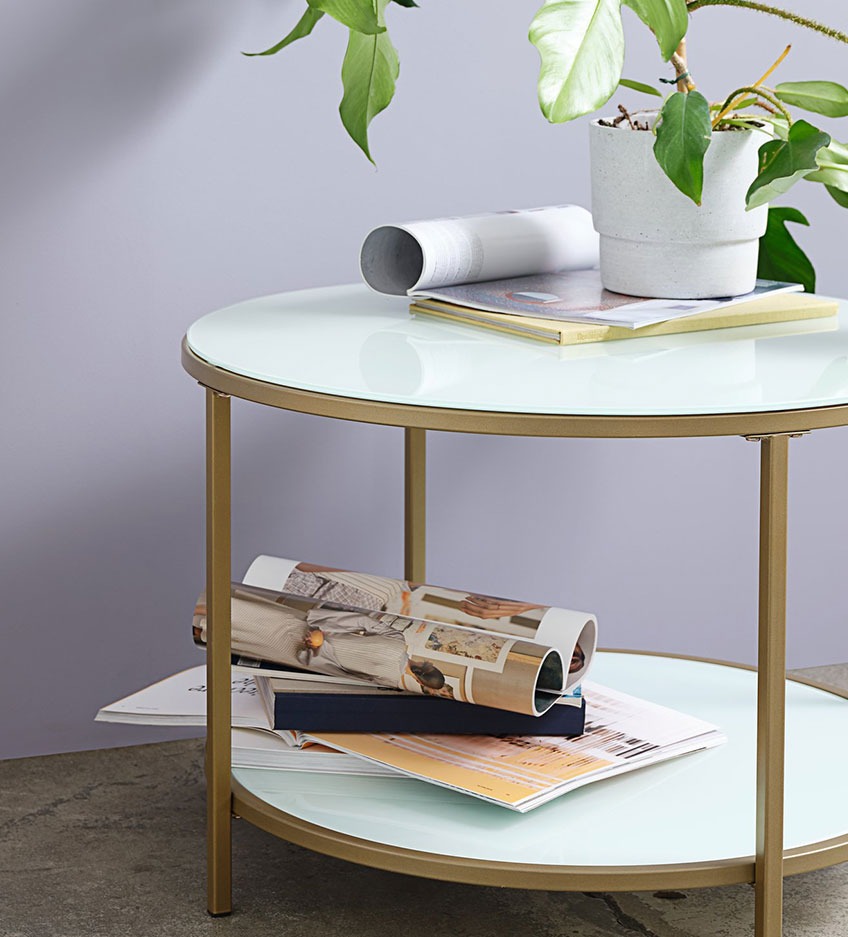 Elegantni okrugli stol bijele površine i zlatnih nogu sa policom