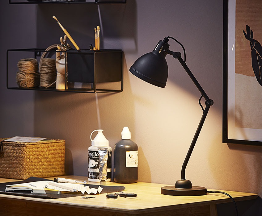 Crna stolna lampa na radnom stolu