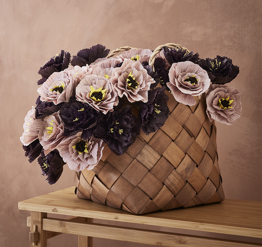 Buket papirnatog cvijeća stilizovan u korpi od pruća