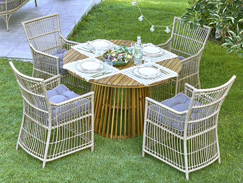 Okrugli baštenski stol sa središnjom bazom i četiri baštenske stolice u bašti