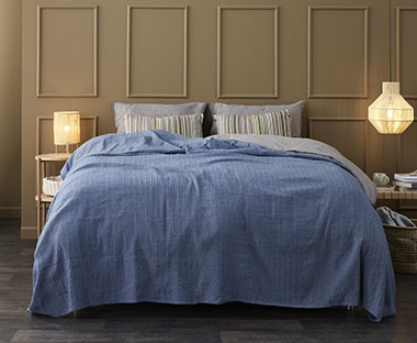 Bračni krevet sa lijepim plavim prekrivačem za krevete