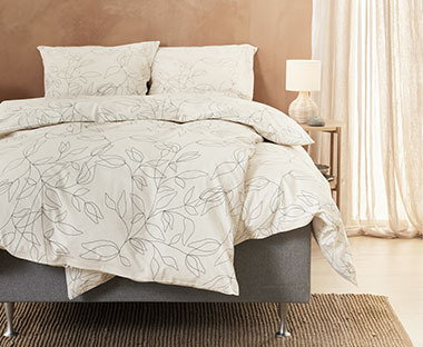 Krevet sa lijepom posteljinom i printom cvjetova