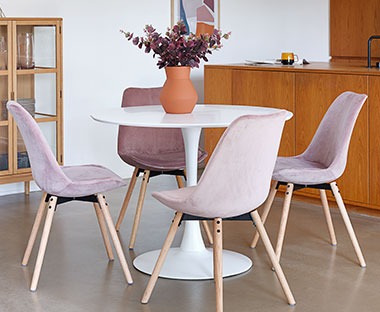 Elegantne roze stolice skandinavskog dizajna oko bijelog okruglog stola