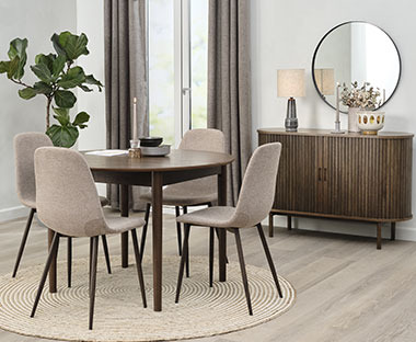 Trpezarija sa okruglim stolom od tamnog drva i sivim stolicama skandinavskog dizajna