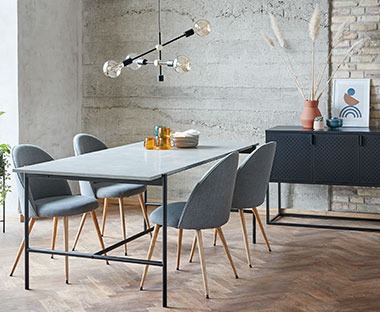 Metalni trpezarijski stol i moderne udobne stolice u trpezariji